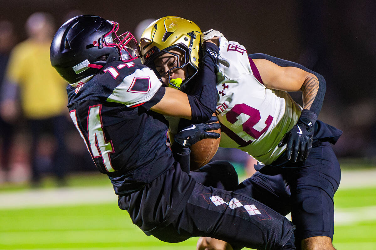 Desert Oasis strong safety Marcelis Santana (14) tackles Faith Lutheran wide receiver Aipa Kulo ...