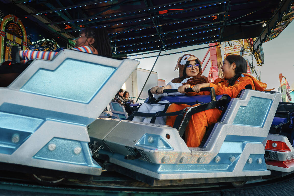 Costumed individuals take in a ride at Halloween Town LV Thursday, Oct. 30, 2025, in Las Vegas ...