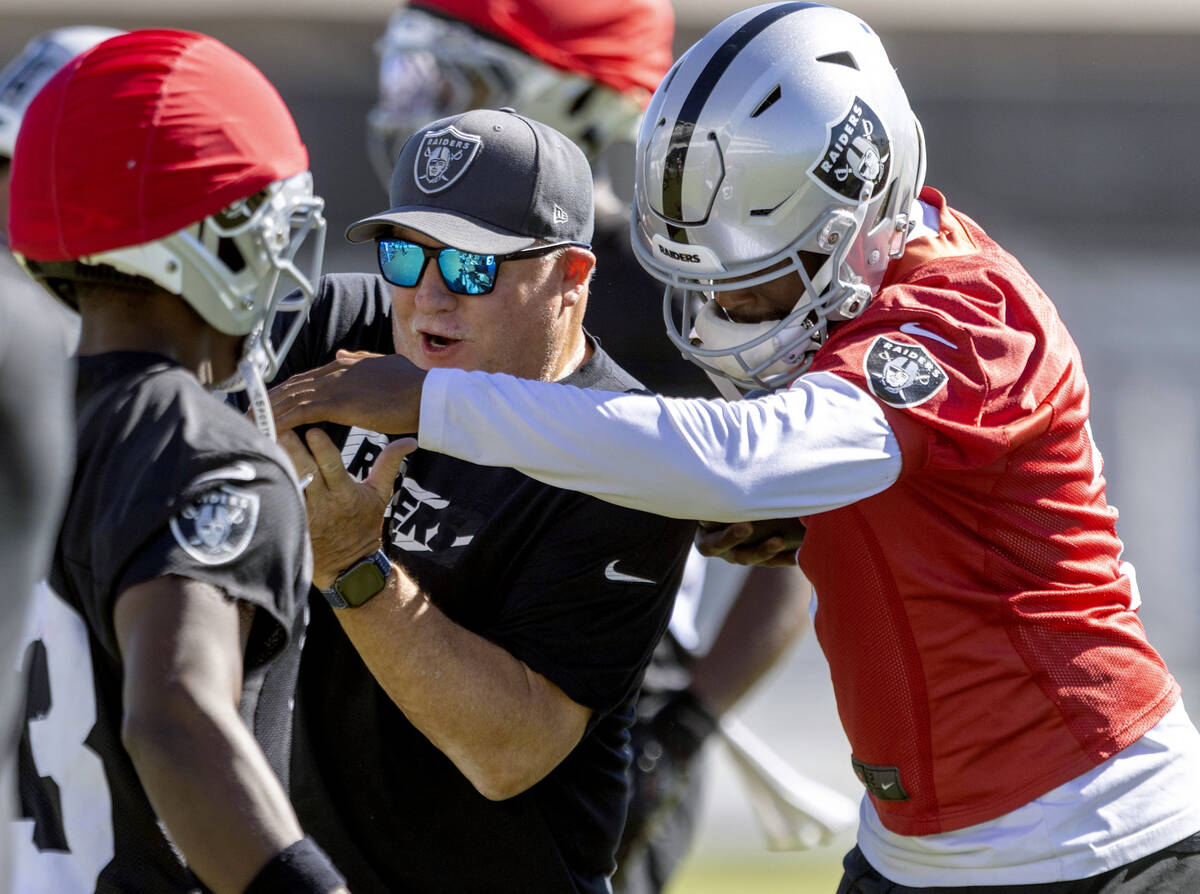 Raiders quarterback Geno Smith (7), right, playfully grabs offensive coordinator Chip Kelly dur ...