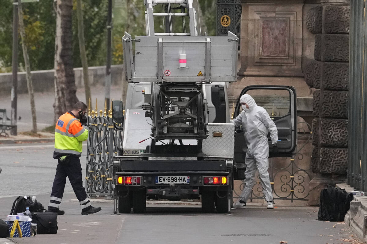 Police officers look for clues by a basket lift used by thieves Sunday, Oct. 19, 2025 at the Lo ...
