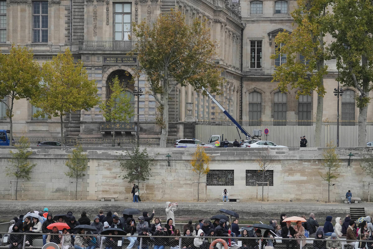 Police officers, background, look for clues by a basket lift used by thieves Sunday, Oct. 19, 2 ...