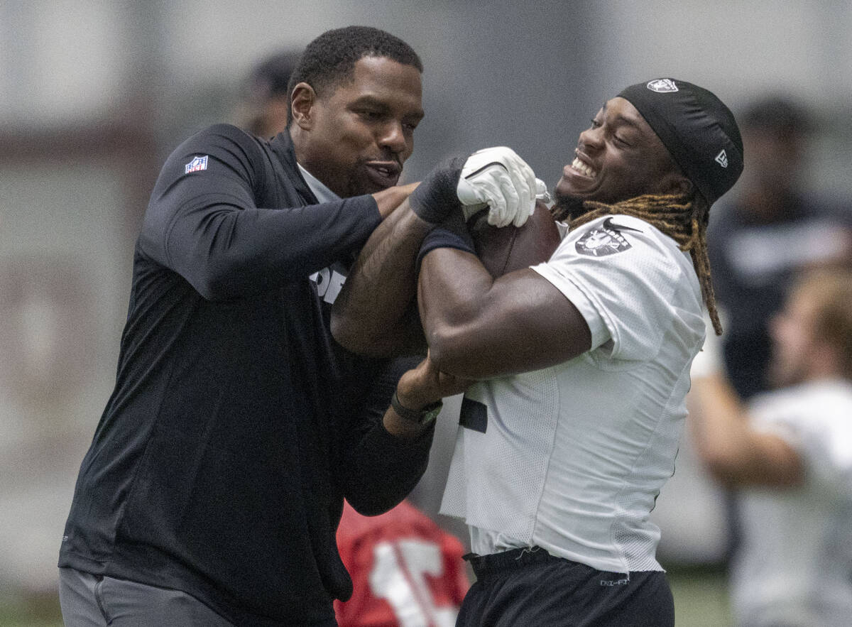 Raiders defensive assistant/linebackers coach Ty McKenzie, left, tests Raiders running back As ...