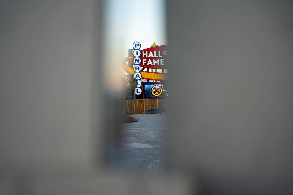 The Pinball Hall of Fame sign is seen through a crack in a wall built around the neighboring Dr ...