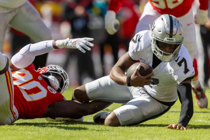 Raiders quarterback Geno Smith (7) is tackled by Kansas City Chiefs defensive end Charles Omeni ...