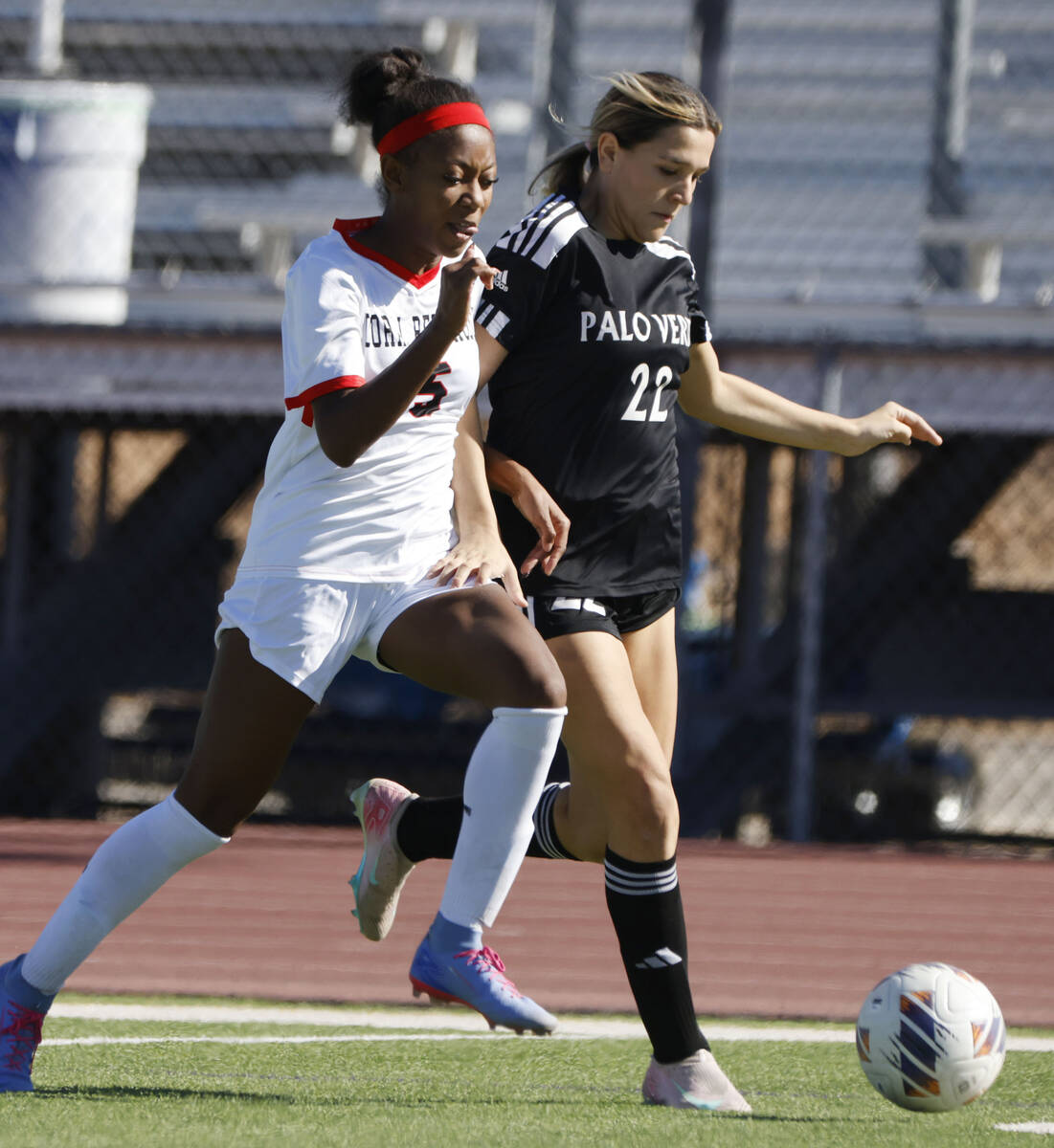 Doral Academy forward Sanyi Thompson (5) and Palo Verde midfielder Caitlynn Nick (22) fight for ...