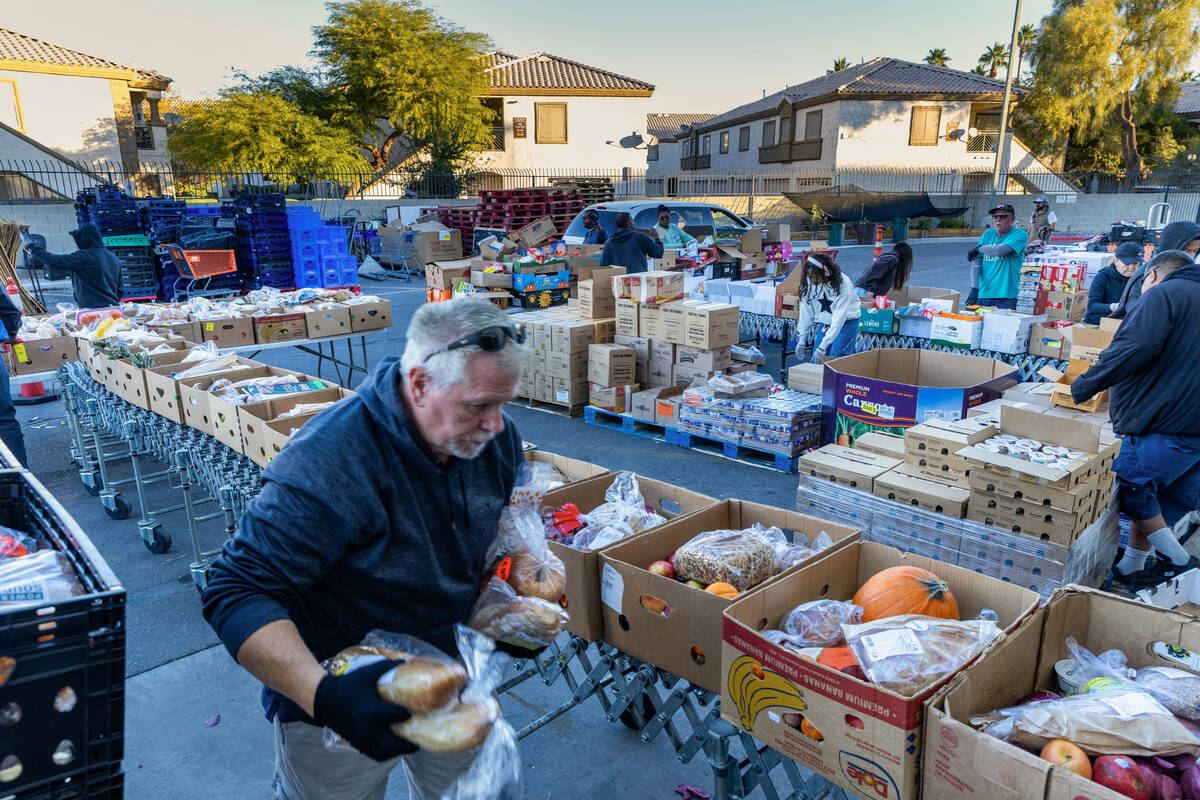 Volunteers pack and distribute food boxes at TCMI Church during the Three Square Food Bank emer ...