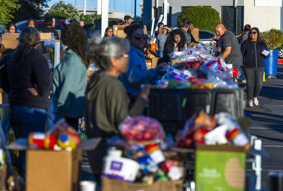 Volunteers pack and distribute food boxes at TCMI Church during the Three Square Food Bank emer ...
