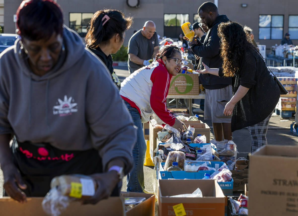 Volunteers pack and distribute food boxes at TCMI Church during the Three Square Food Bank emer ...