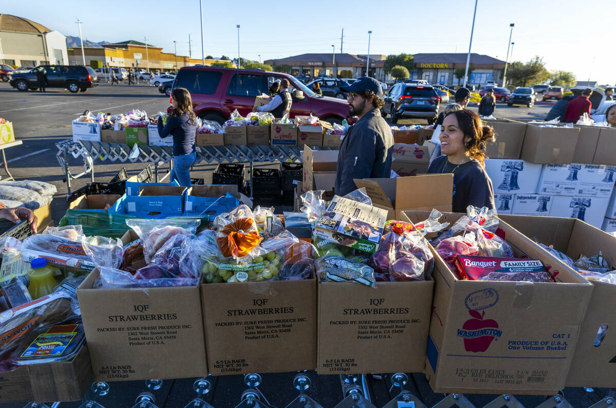 Volunteers pack and distribute food boxes at TCMI Church during the Three Square Food Bank emer ...