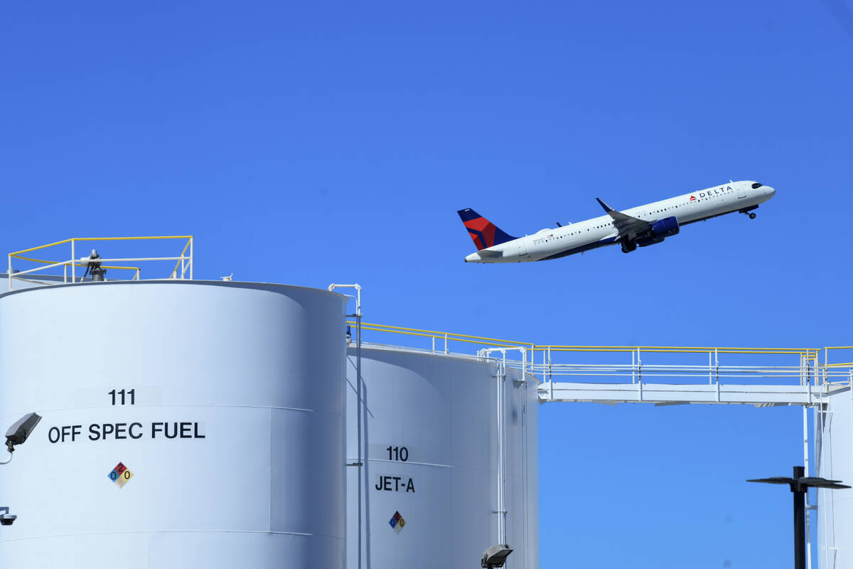 Fuel tanks are seen in the foreground as a jet departs Harry Reid International Airport Saturda ...