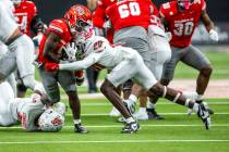 UNLV running back Jai'Den Thomas (9) is hit hard on a stop by New Mexico Lobos linebacker ...