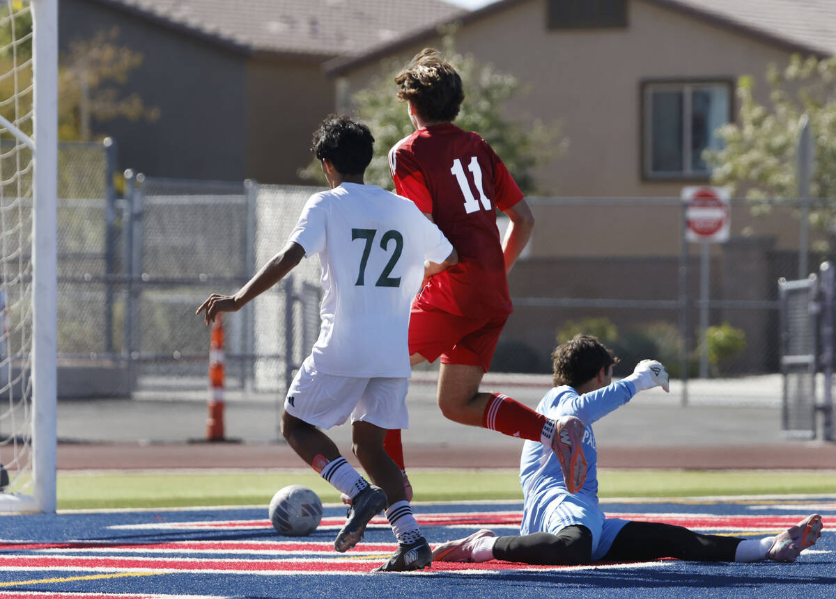 Coronado striker Gavin Flickinger (11) drives past Palo Verde goalkeeper Jake Barrett to score ...