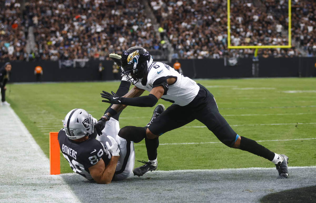 Raiders tight end Brock Bowers (89) scores a touchdown under pressure from Jacksonville Jaguars ...