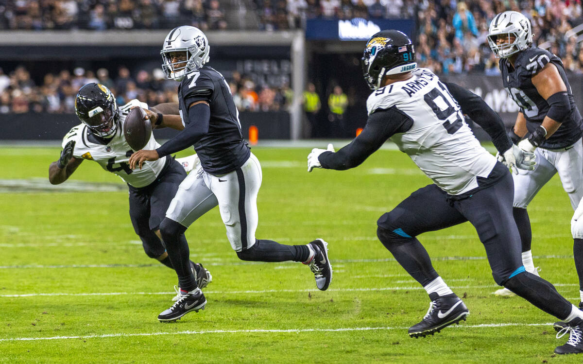 Raiders quarterback Geno Smith (7) looks to pass on a scramble as Jacksonville Jaguars defensiv ...