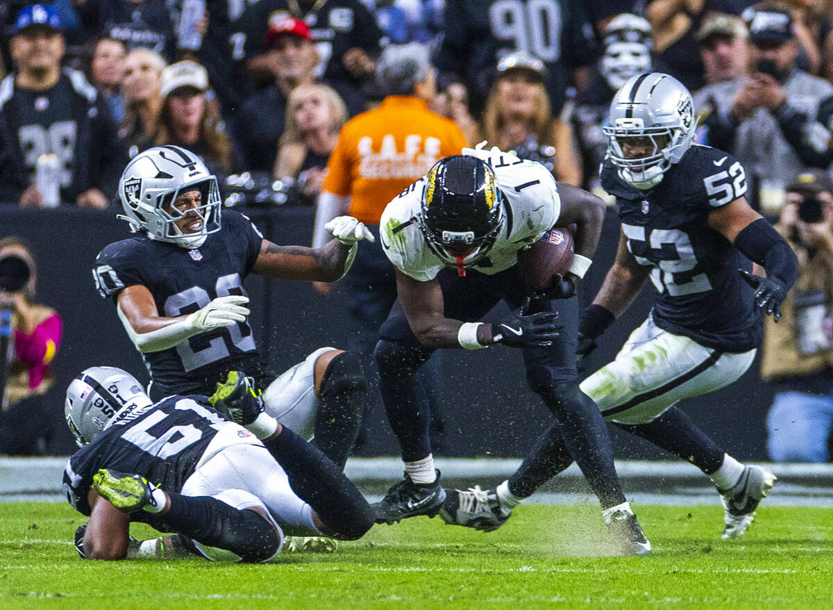 Jacksonville Jaguars running back Travis Etienne Jr. (1) collides with Raiders safety Isaiah Po ...