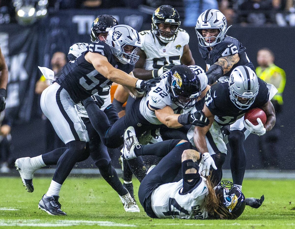 Raiders running back Raheem Mostert (31) fights for more yards driving Jacksonville Jaguars lin ...