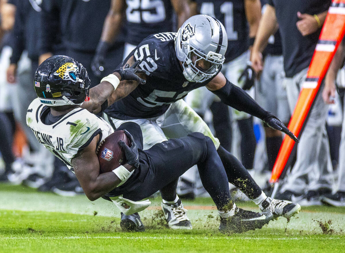 Jacksonville Jaguars running back Travis Etienne Jr. (1) is taken off his feet for a stop by Ra ...