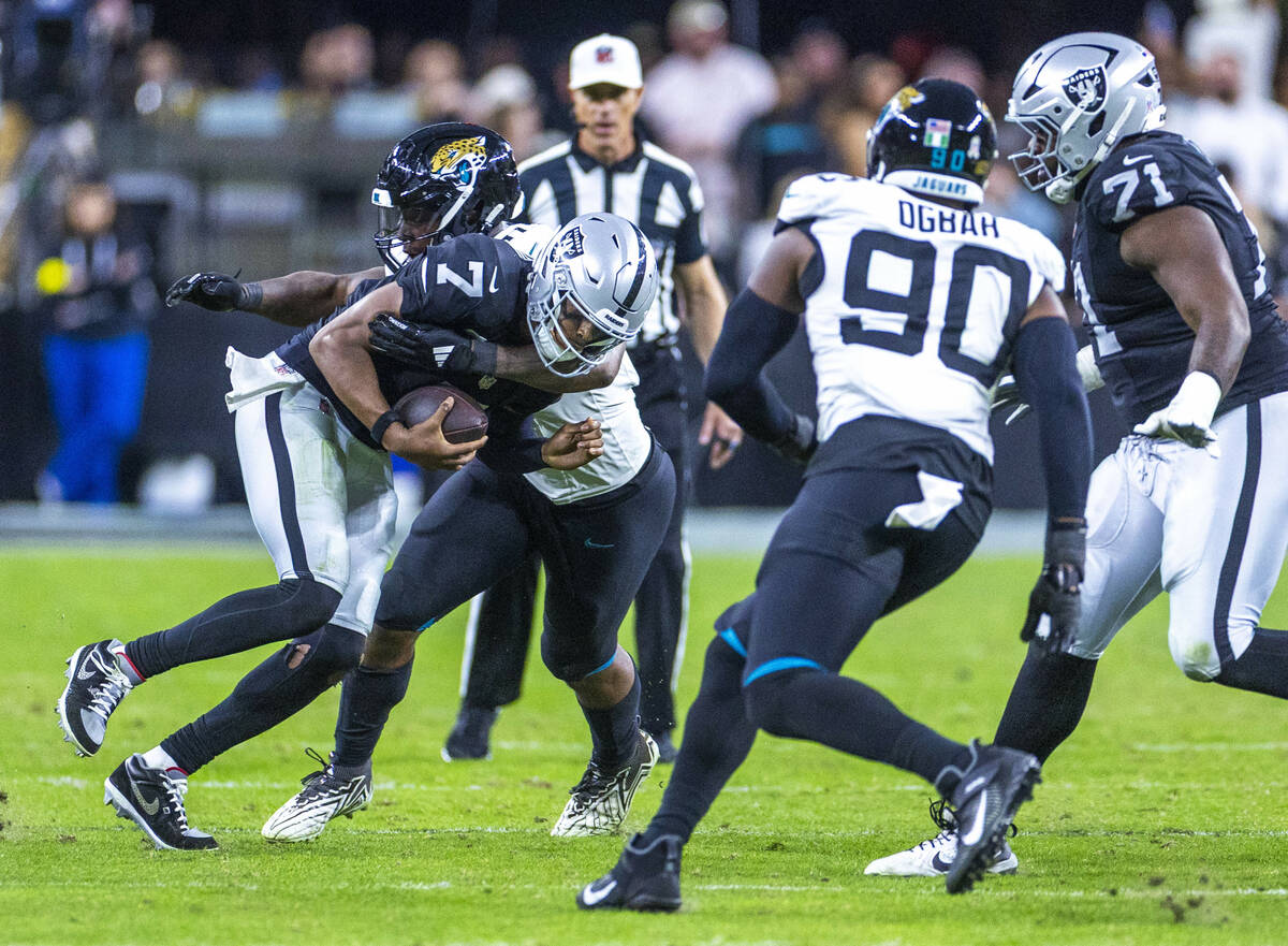 Raiders quarterback Geno Smith (7) is sacked by Jacksonville Jaguars defensive end Josh Hines-A ...