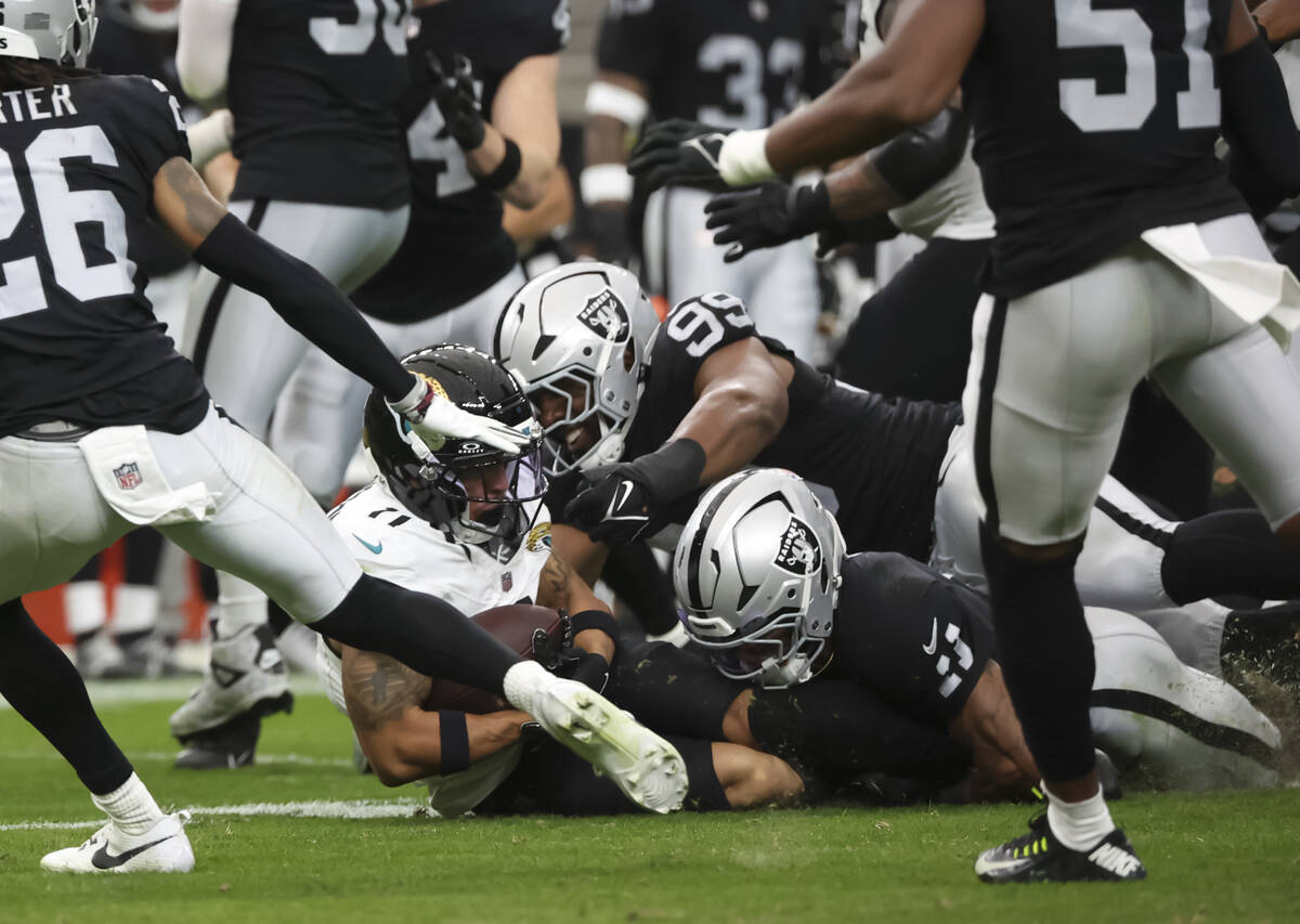 Jacksonville Jaguars wide receiver Parker Washington (11) gets tackled by Raiders defensive tac ...