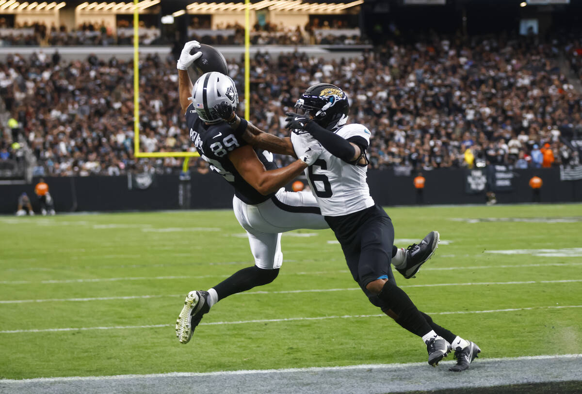 Raiders tight end Brock Bowers (89) scores a touchdown under pressure from Jacksonville Jaguars ...