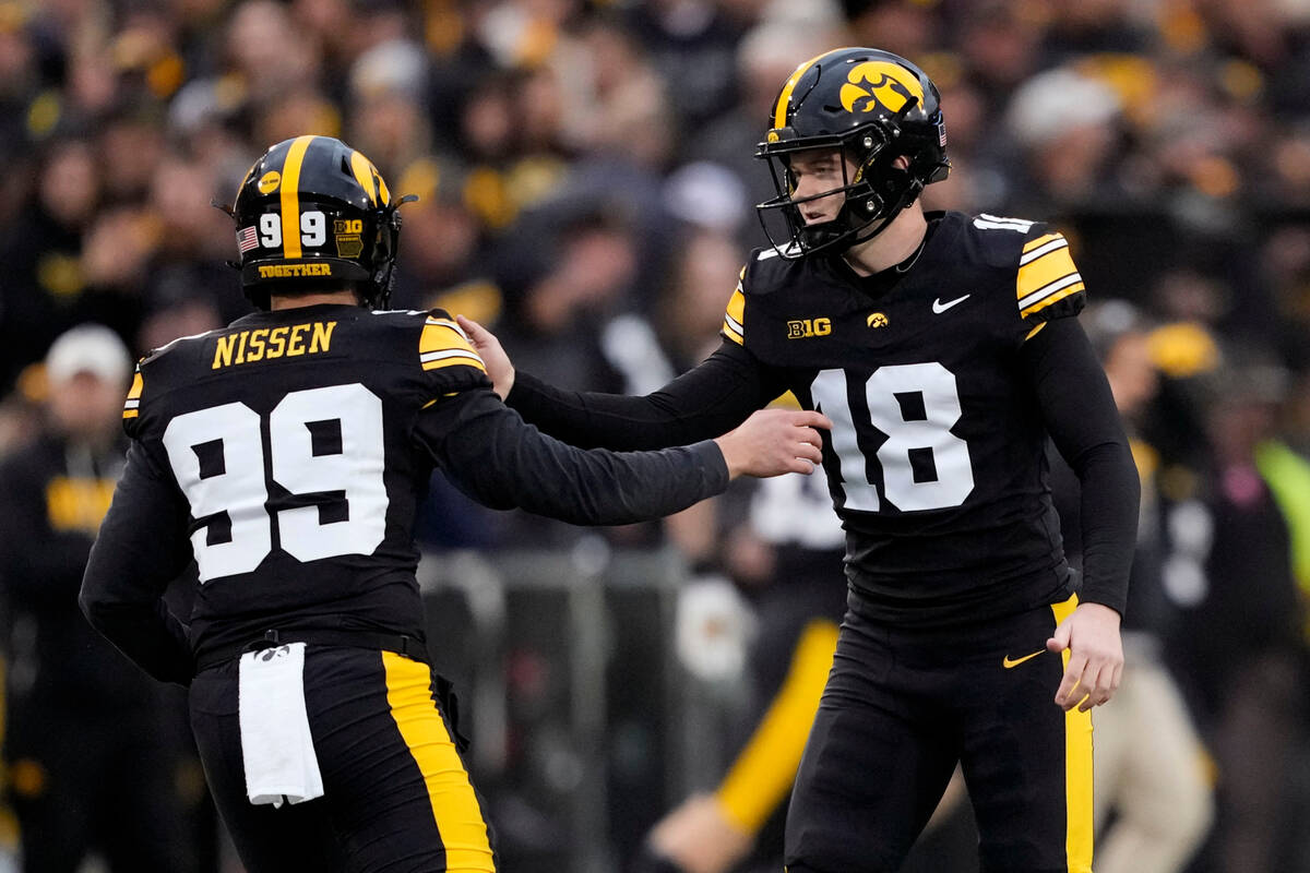 Iowa kicker Drew Stevens (18) celebrates with teammate Ty Nissen (99) after kicking a field goa ...