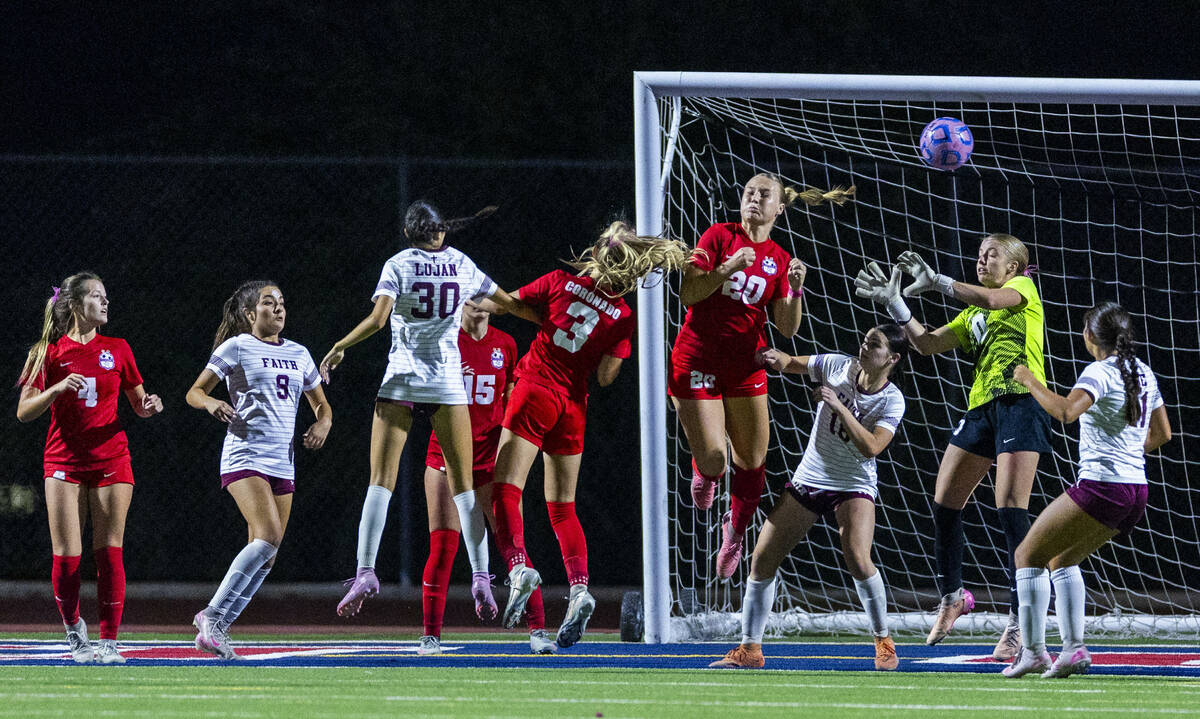 Coronado's Cate Gusick (20) heads the ball away from Faith Lutheran players and goalie Lil ...