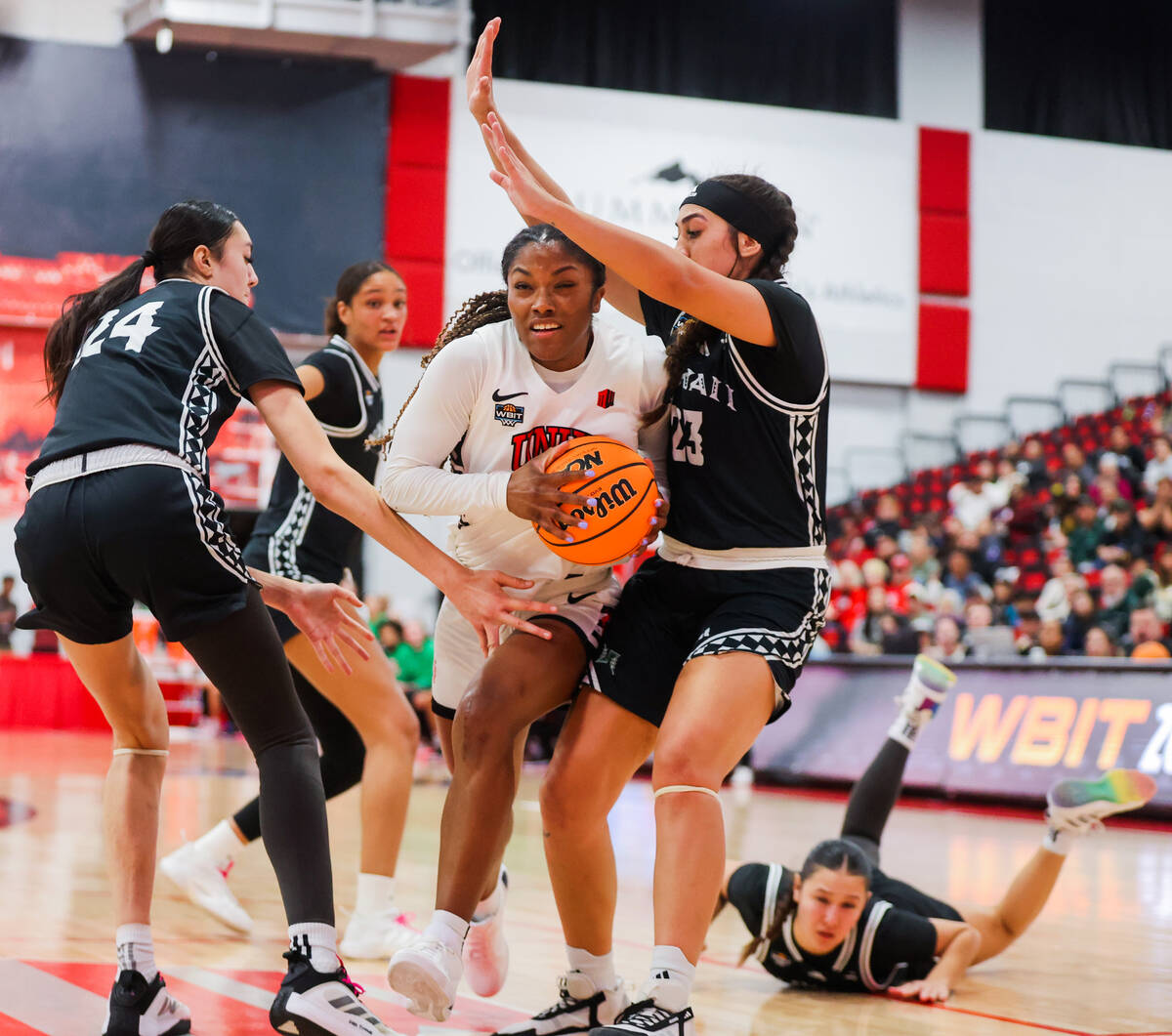 Lady Rebels guard Aaliyah Alexander (25) breaks through Hawai'i Rainbow Wahine defense as ...