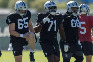 Raiders guard Alex Cappa (65), offensive tackle DJ Glaze (71), and guard Dylan Parham (66) warm ...