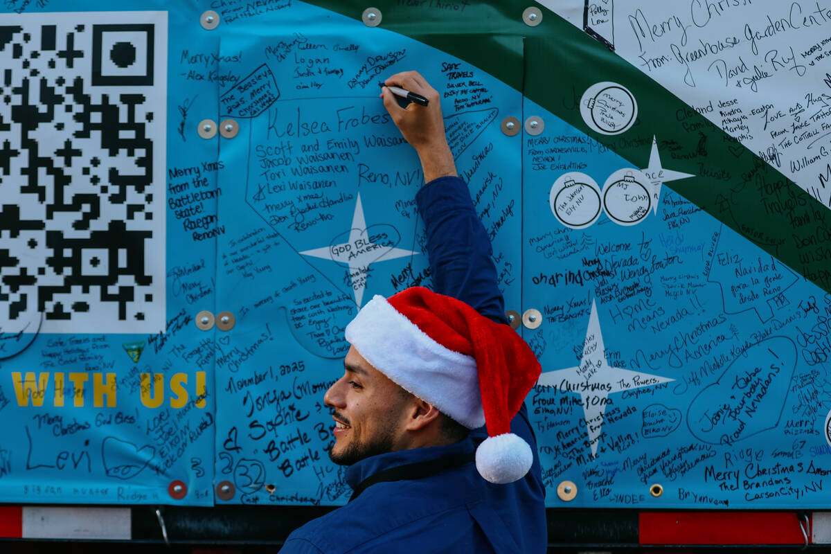 Alex Santana, with Vegas Chamber, signs the truck holding the U.S. Capitol Christmas tree, nick ...