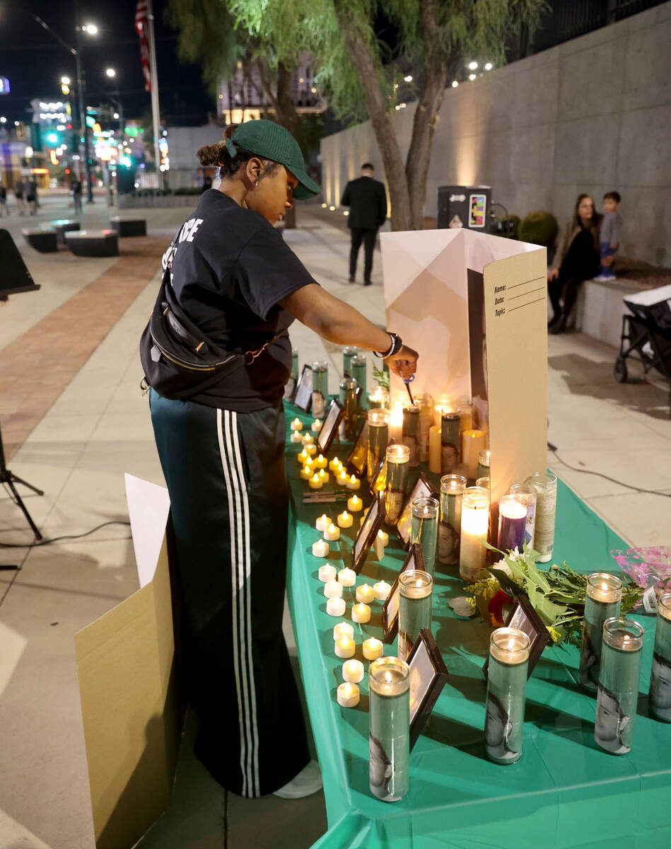 Tori, who declined to give her last name, with More Than A Hashtag, lights candles during a vig ...