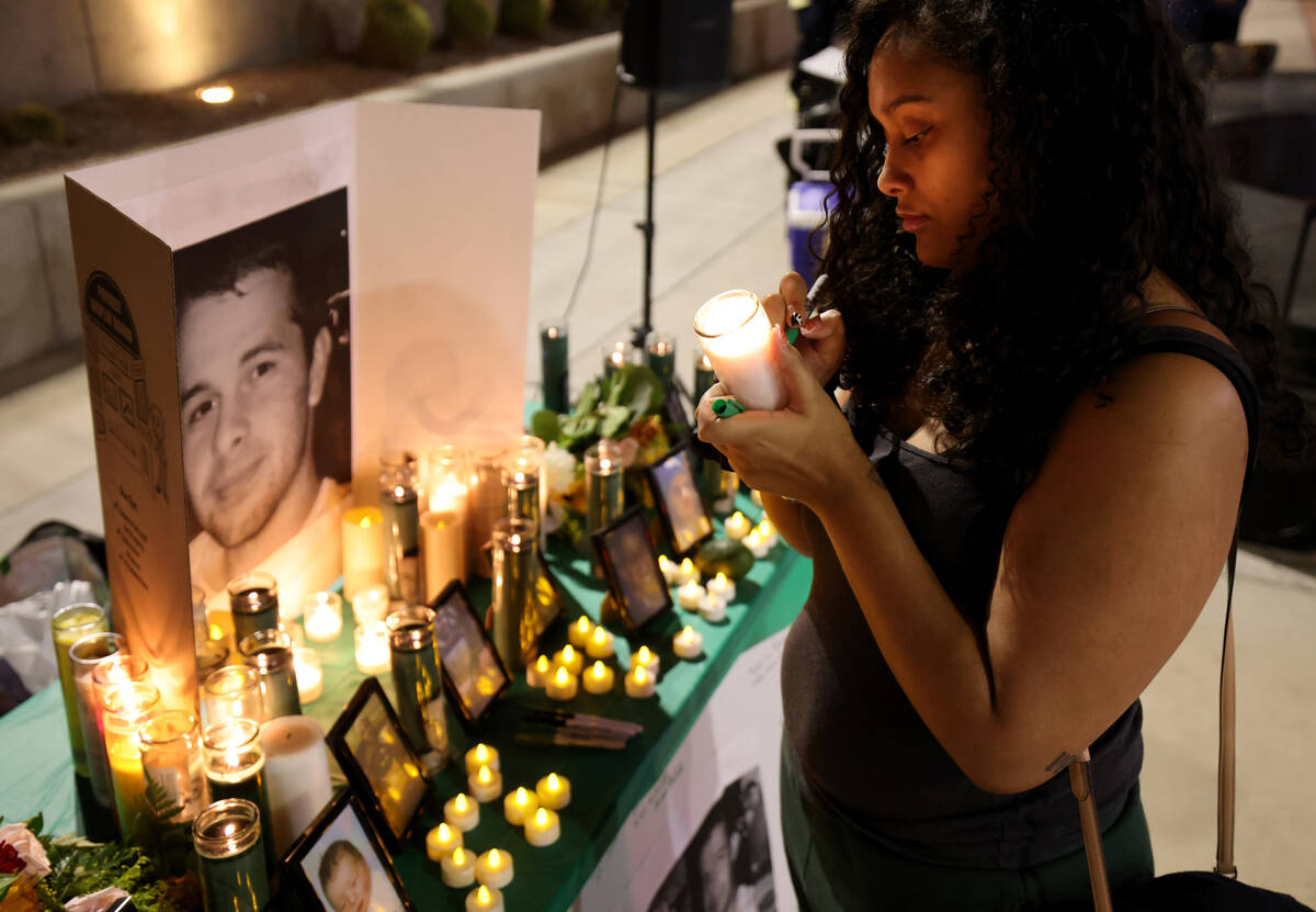 Destiny Smith signs a candle during a vigil for Jorge Gomez outside the Lloyd George U.S. Court ...