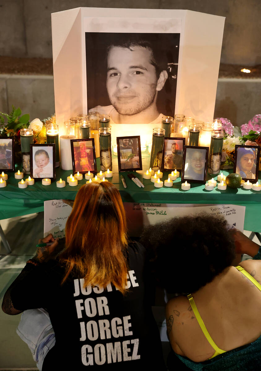 Kimberly Simbajon, left, and Briannamarie Alves sign a photo during a vigil for Jorge Gomez out ...