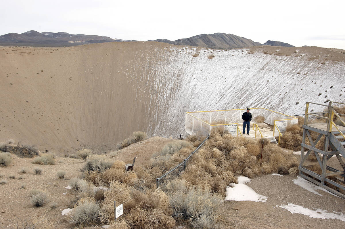 Nevada Test Site historian Ernie Williams stands on the observation deck for the Sedan crater, ...