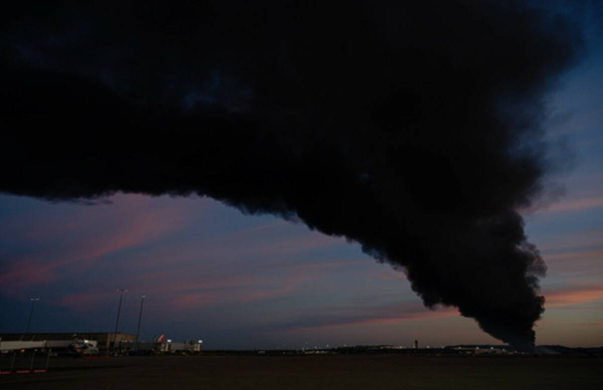 A plume of smoke wafts over airport property after reports of a plane crash at Louisville Inter ...