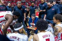 UNLV head coach Josh Pastner talks with his players as they huddle on a timeout during the firs ...