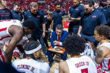 UNLV head coach Josh Pastner talks with his players as they huddle on a timeout during the firs ...