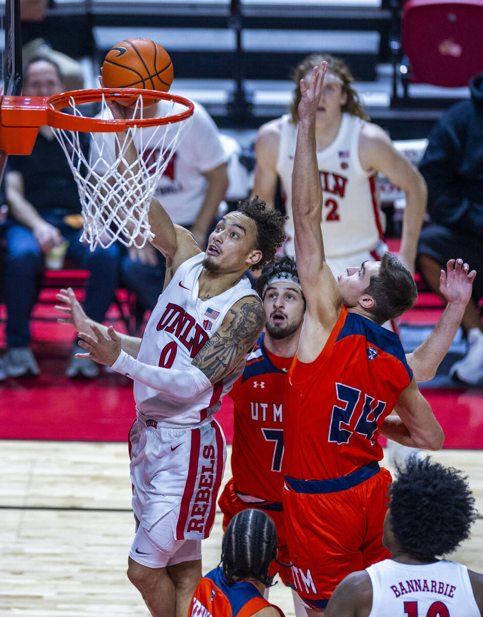 UNLV guard Dra Gibbs-Lawhorn (0) elevates inside of UT Martin Skyhawks guard Dragos Lungu (7) a ...