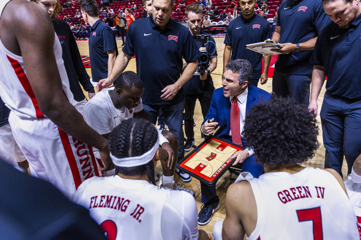 UNLV head coach Josh Pastner counsels his players in a huddle on a timeout against the UT Marti ...
