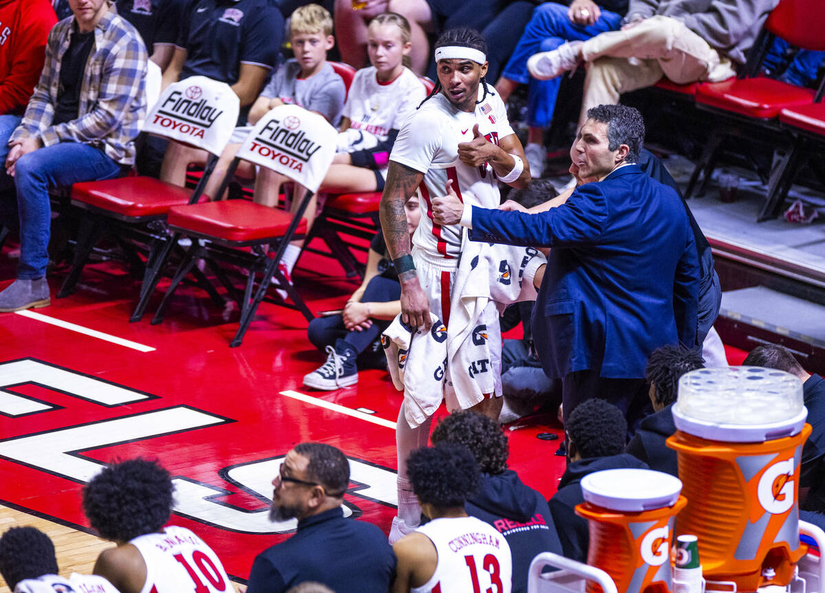 UNLV head coach Josh Pastner and guard Howie Fleming Jr. (3) signal he's good to return to ...