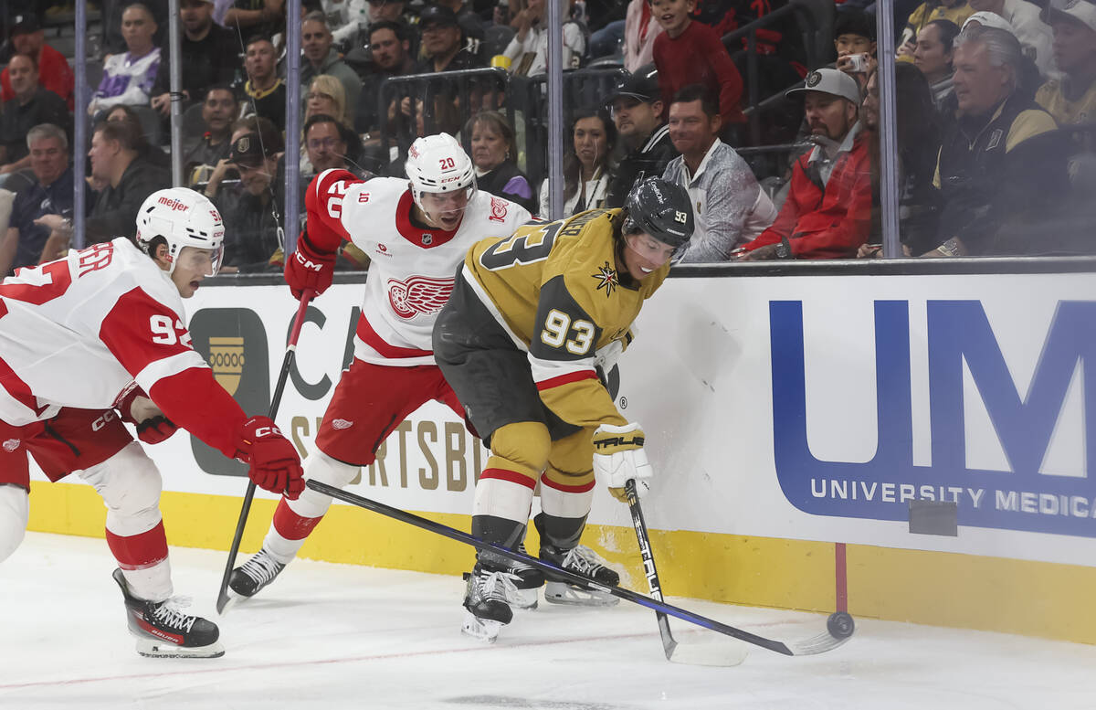Detroit Red Wings center Marco Kasper (92) gets the puck away from Golden Knights right wing Mi ...