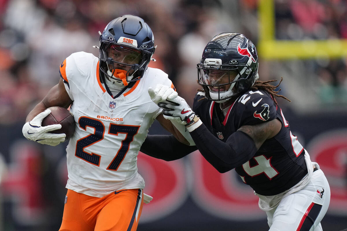 Denver Broncos running back J.K. Dobbins (27) is hit by Houston Texans cornerback Derek Stingle ...