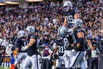 Raiders tight end Brock Bowers (89) is lifted up by Raiders center Jackson Powers-Johnson (58) ...