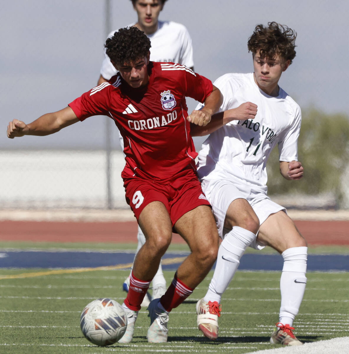 Coronado midfielder Dylan Flores (9) protects the ball from Coronado forward Noah Johnson (11) ...