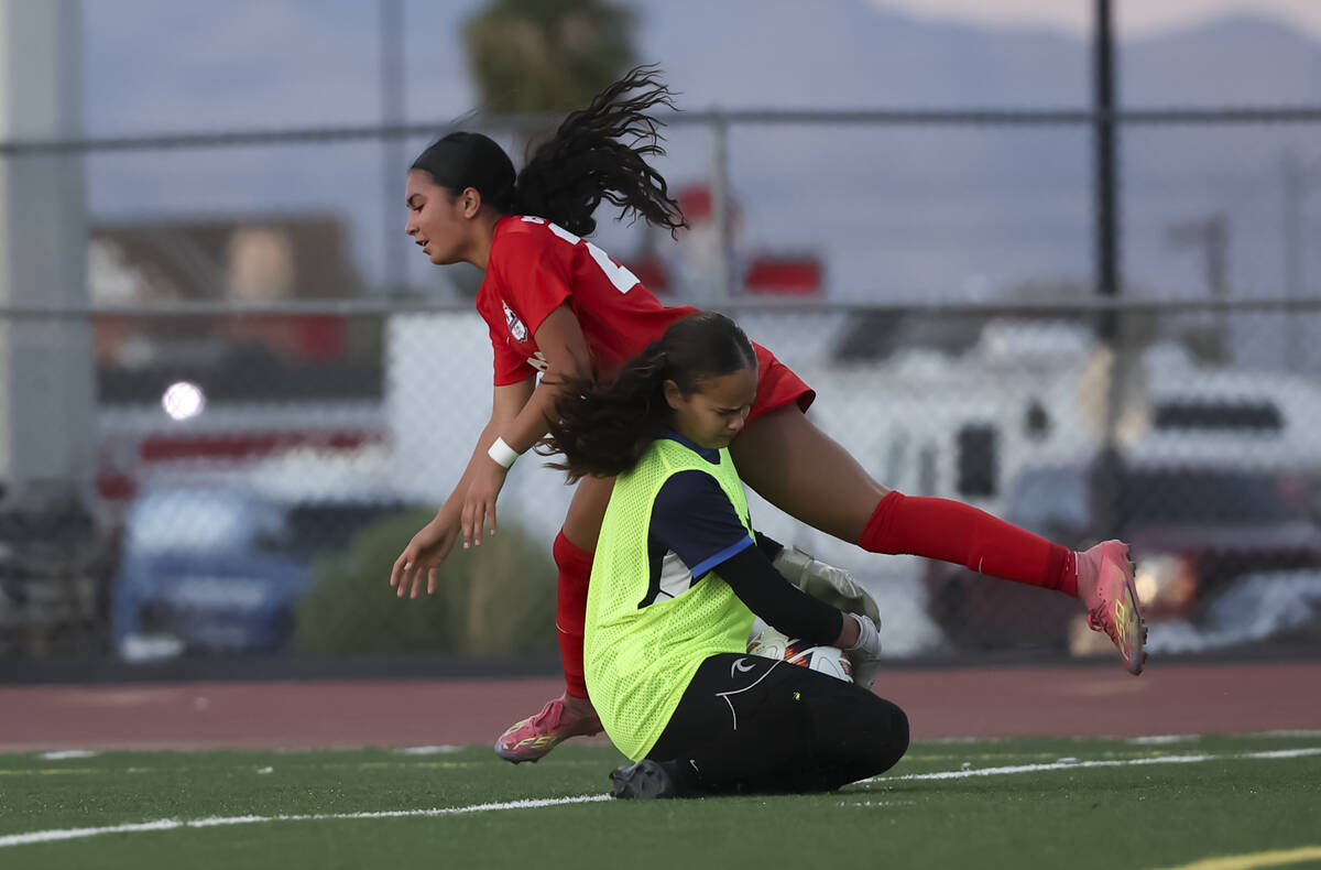Coronado's Taylor Takahashi (22) collides with Centennial goalkeeper Madelyn Hartman (49) ...