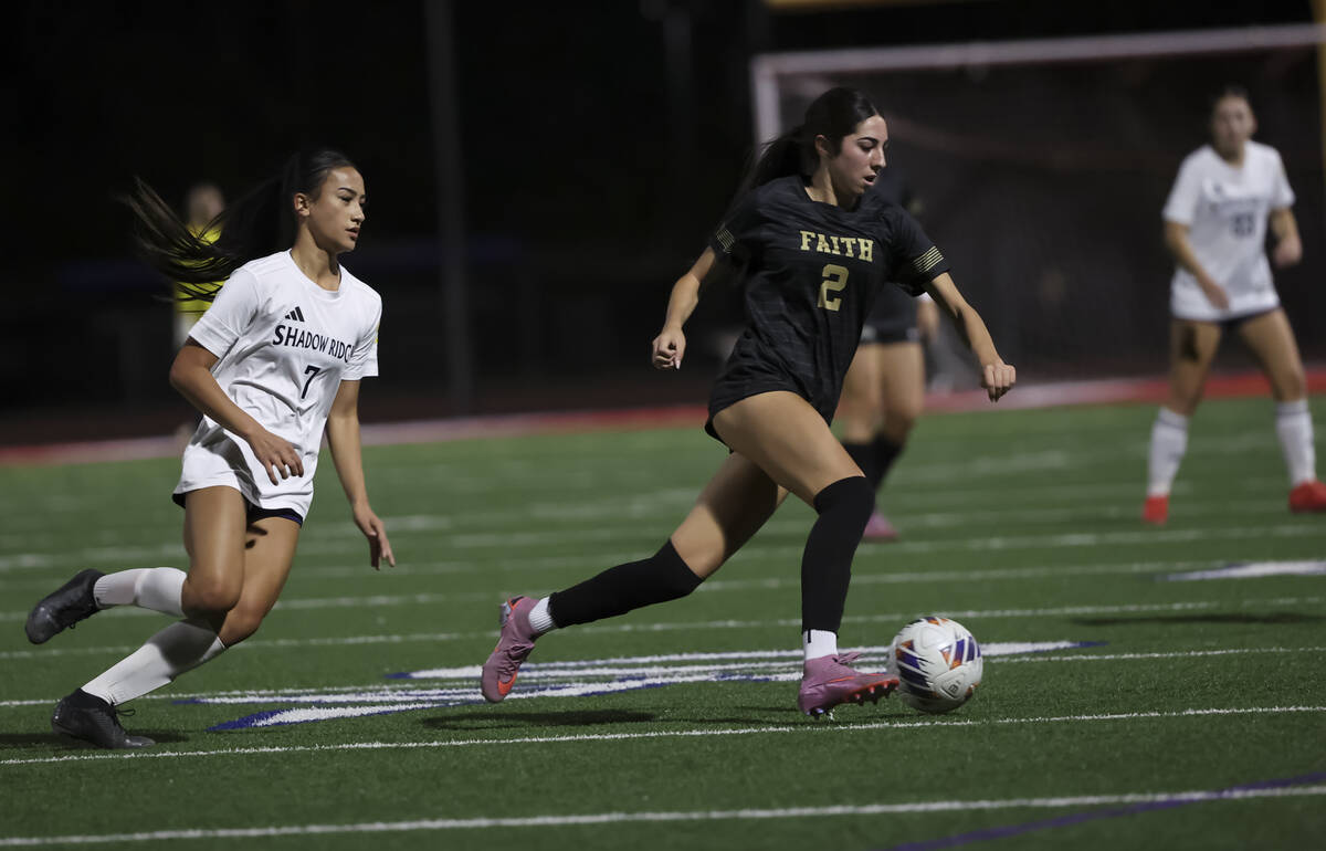 Faith Lutheran's Elliott Lujan (2) runs with the ball as Shadow Ridge's Carmen Loo (7 ...