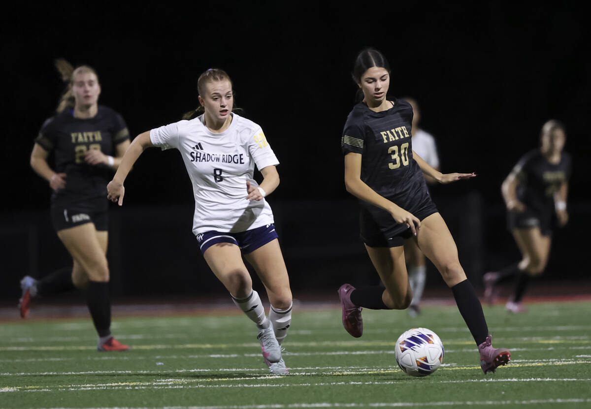 Faith Lutheran's Presley Lujan (30) runs with the ball under pressure from Shadow Ridge� ...