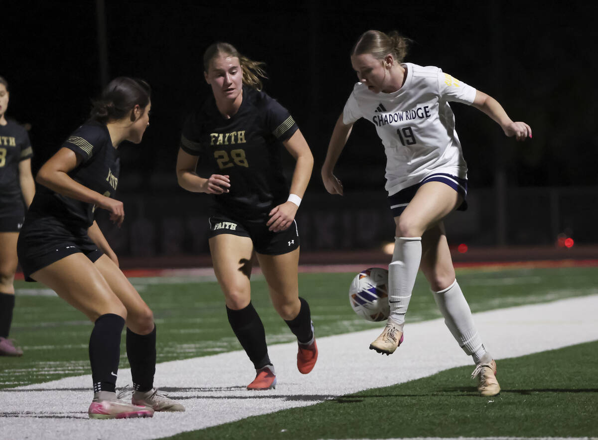 Shadow Ridge's Courtney Howard (19) kicks the ball as Faith Lutheran's Allie Rabe (28 ...