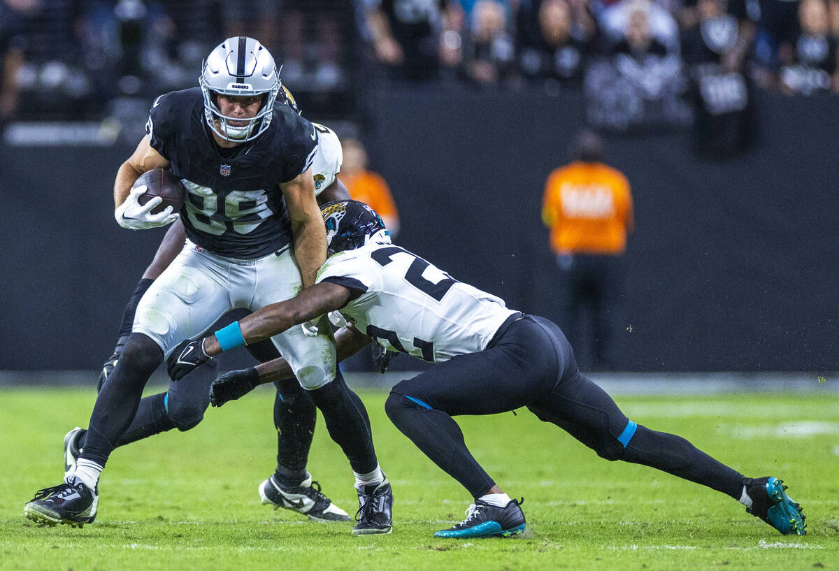 Raiders tight end Brock Bowers (89) works to fend off Jacksonville Jaguars cornerback Jarrian J ...