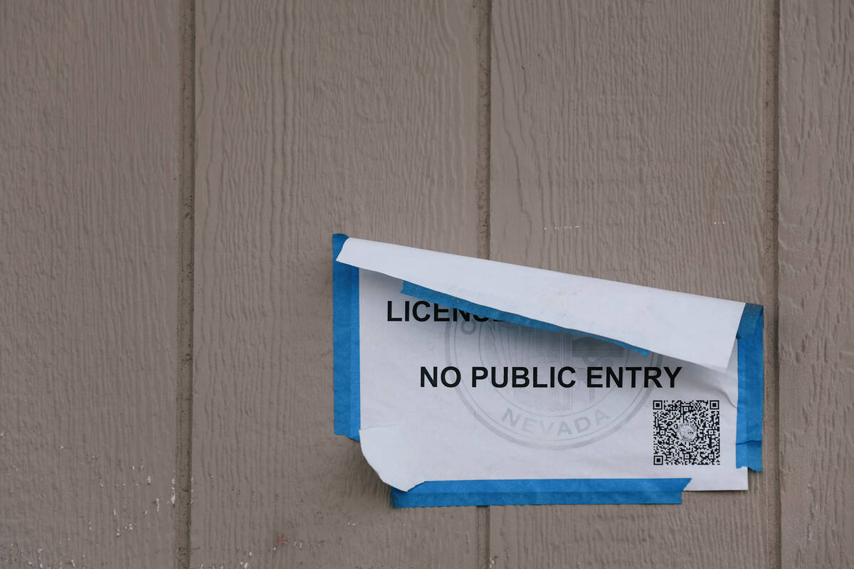 A sign reading, “all business licenses suspended, no public entry” sticks to the side of th ...
