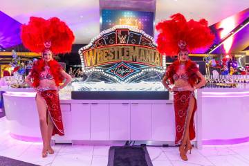Showgirls stand before an ice sculpture during a WrestleMania kickoff party hosted by experienc ...